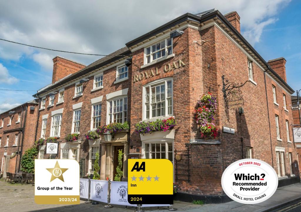 a brick building with a yellow sign in front of it at The Royal Oak Hotel, Welshpool, Mid Wales in Welshpool