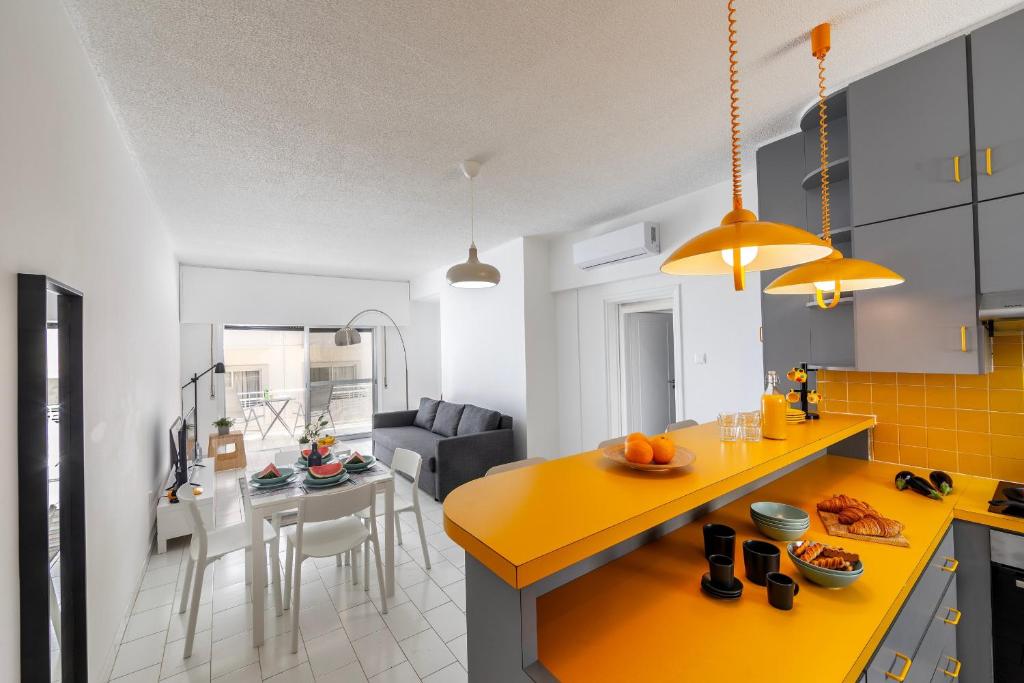 una cucina e un soggiorno con piano di lavoro giallo di Protaras O2 Seaside Suite a Protaras