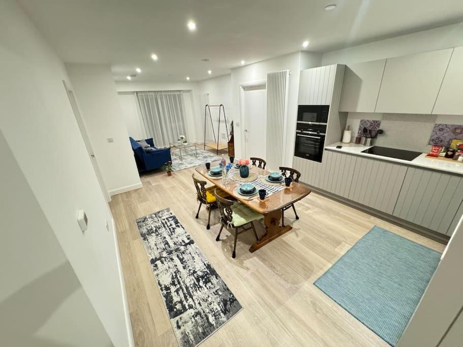 uma cozinha e sala de estar com mesa e cadeiras em Stay@Inaara Property-Contemporary 2 Bedroom Apartment with Ensuite em Londres