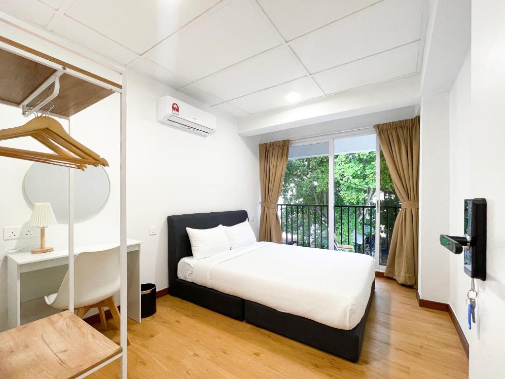a white bedroom with a bed and a window at Lili Stay by the beach in George Town