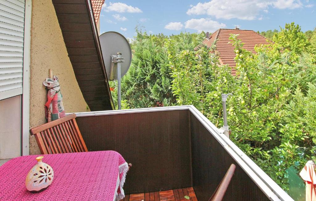 a table with a pink table cloth on a balcony at Cozy Home In Waren mritz With Kitchen in Kölpinsee