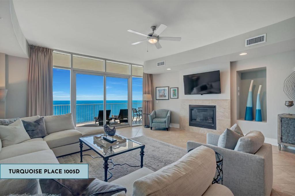 ein Wohnzimmer mit Sofa, Kamin und Meerblick in der Unterkunft Turquoise Place 1005d in Orange Beach