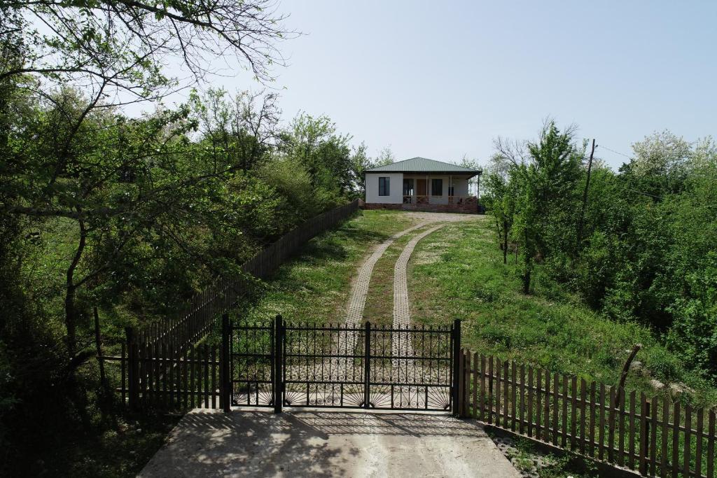 a gate in front of a house on a dirt road at Renovated 3-bedroom House in Nature - Iskia Estate in Martvili