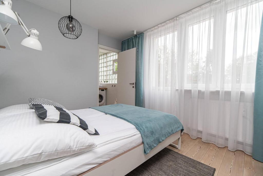 a bedroom with a bed and a large window at Apartment by the Castle - top spot in Szczecin in Szczecin