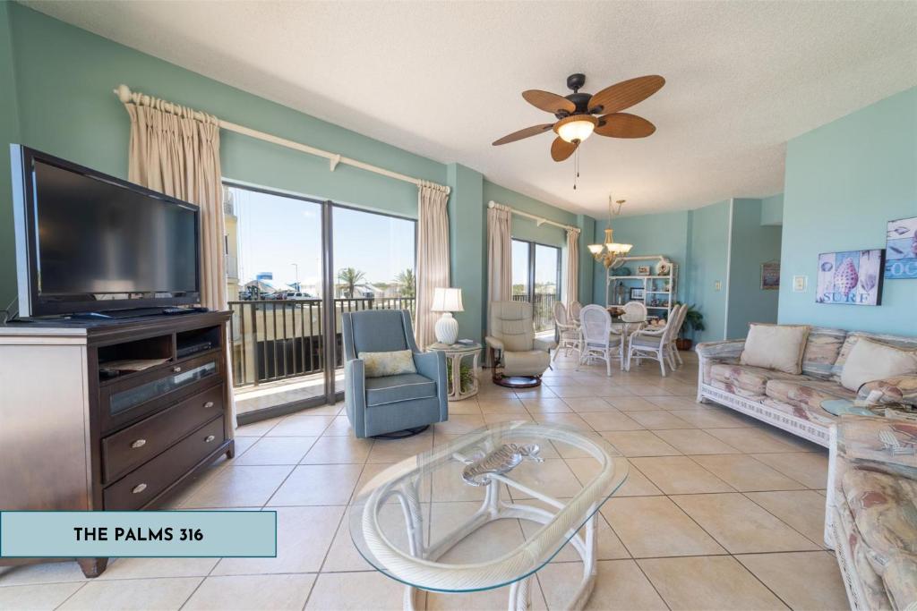 uma sala de estar com uma televisão de ecrã plano e um sofá em Gulf Front Condo Wrap-Around Balcony 316 em Orange Beach