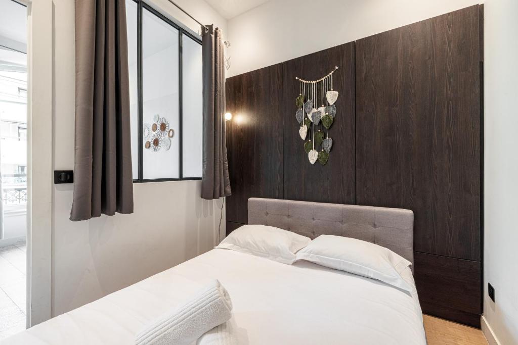 une chambre avec un lit avec une tête de lit en bois dans l'établissement Cozy 1 Bdr Downtown, à Nice