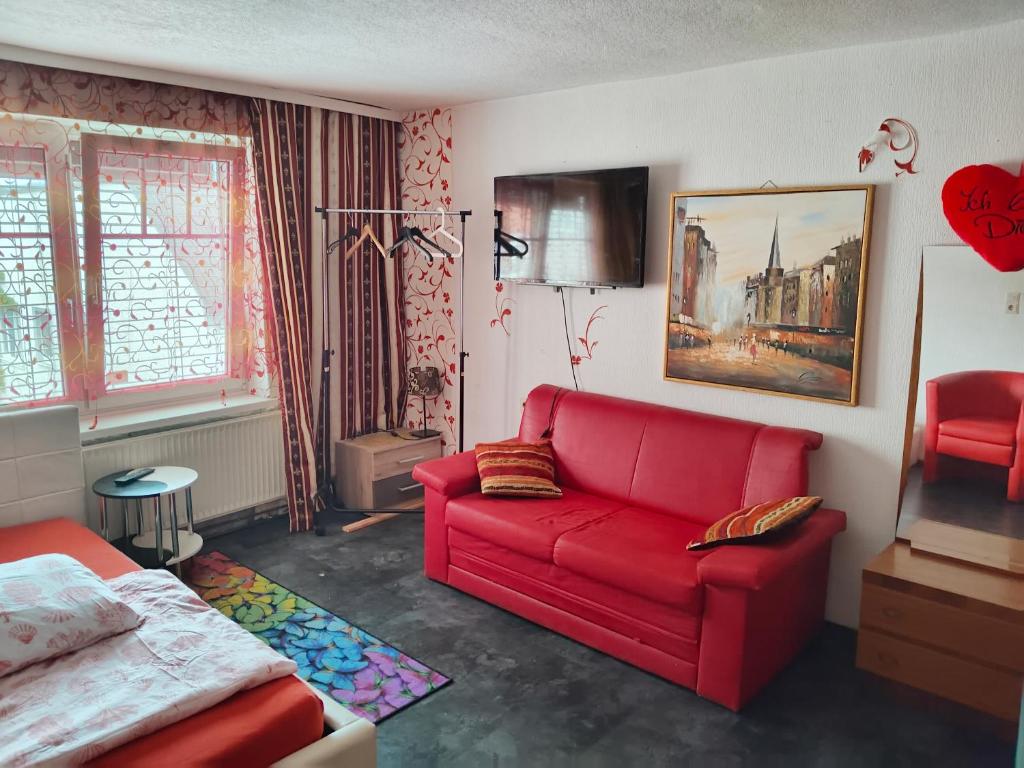 salon z czerwoną kanapą i łóżkiem w obiekcie Apartment in Salzkammergut w mieście Attnang-Puchheim