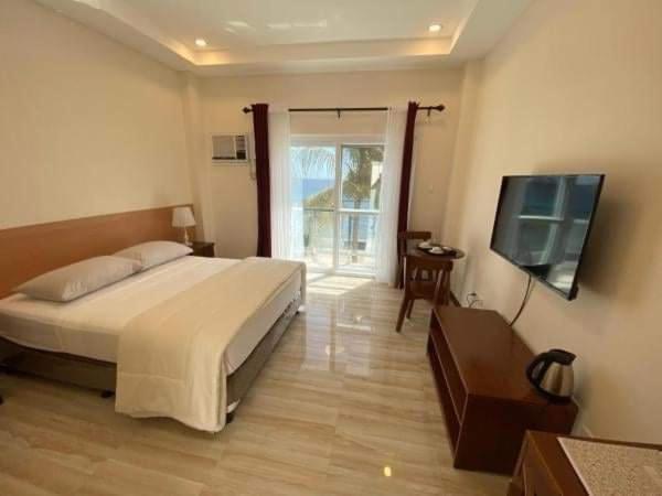 Hotel Eight Fifty في Jagna: غرفة نوم بسرير وتلفزيون بشاشة مسطحة