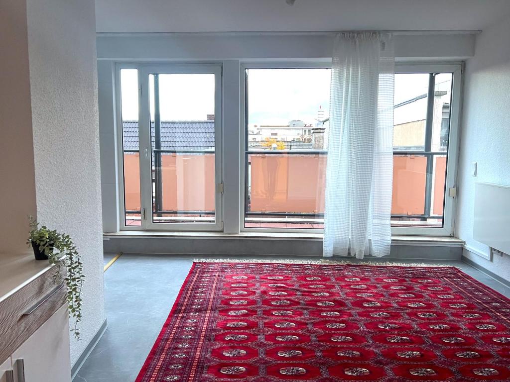 een kamer met grote ramen en een rood tapijt bij Penthouse Apartment Dortmund City in Dortmund