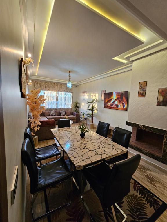- une salle à manger avec une table, des chaises et un canapé dans l'établissement MIA Appartement - résidence les champs du printemps, à Casablanca