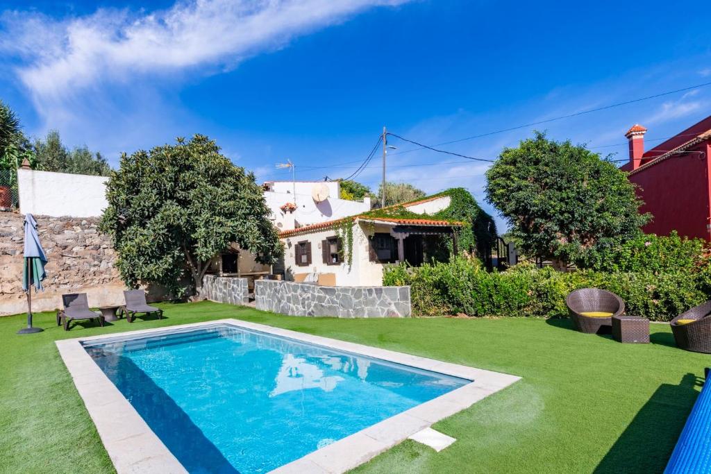 een achtertuin met een zwembad en een huis bij Casa Rural Mi Perlita in Vega de San Mateo