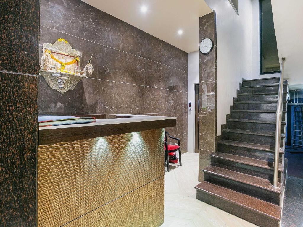 a lobby with a staircase and a counter and a stair case at Hotel Prince Residency in Thane