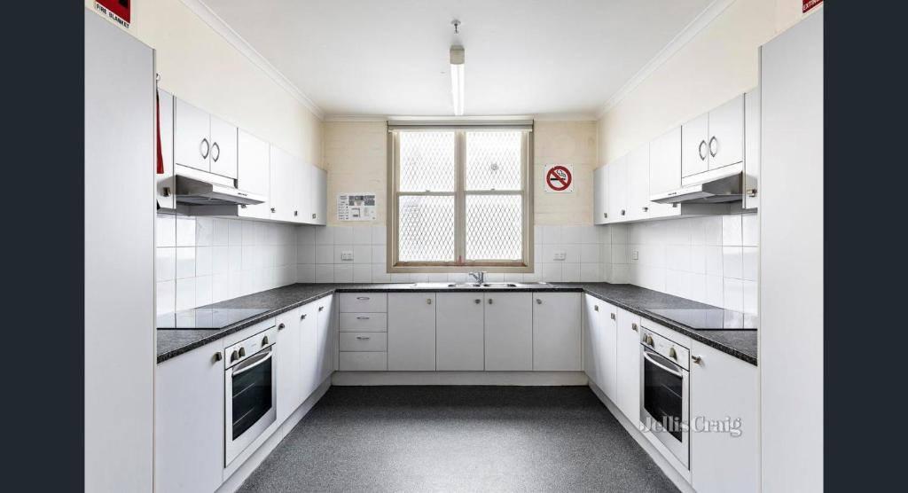 une cuisine blanche avec des placards blancs et une fenêtre dans l'établissement Ausis Accommodation Services, à Melbourne