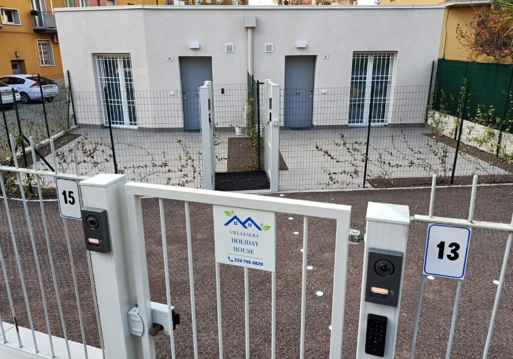 a fence with signs on it in front of a building at Villa Laura Holiday House 2 in Bologna