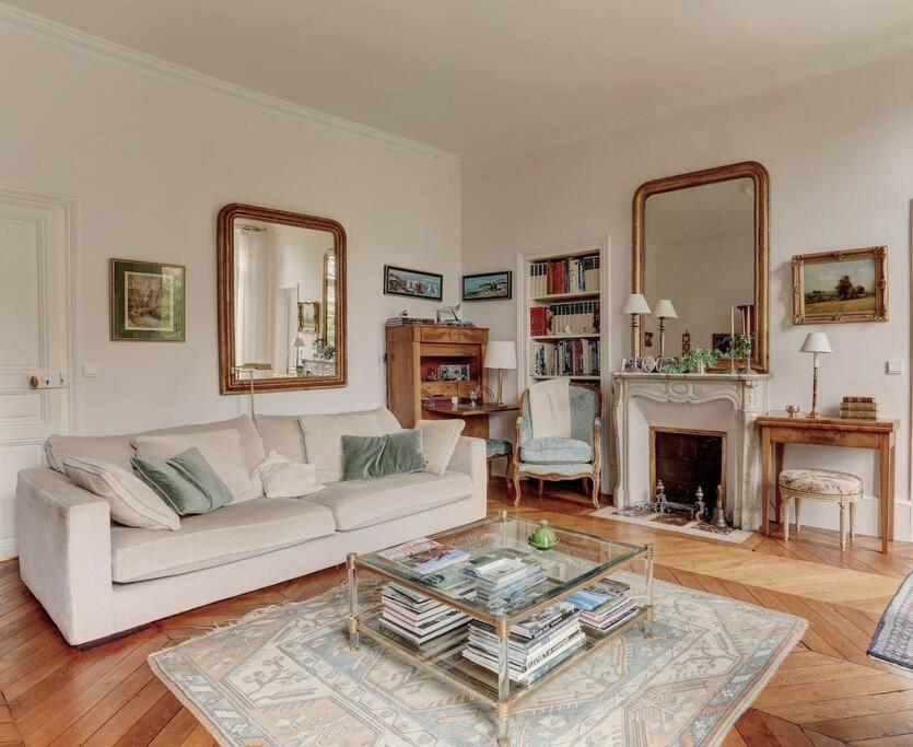 un salon avec un canapé blanc et une table en verre dans l'établissement LE Saint Martin, à Versailles