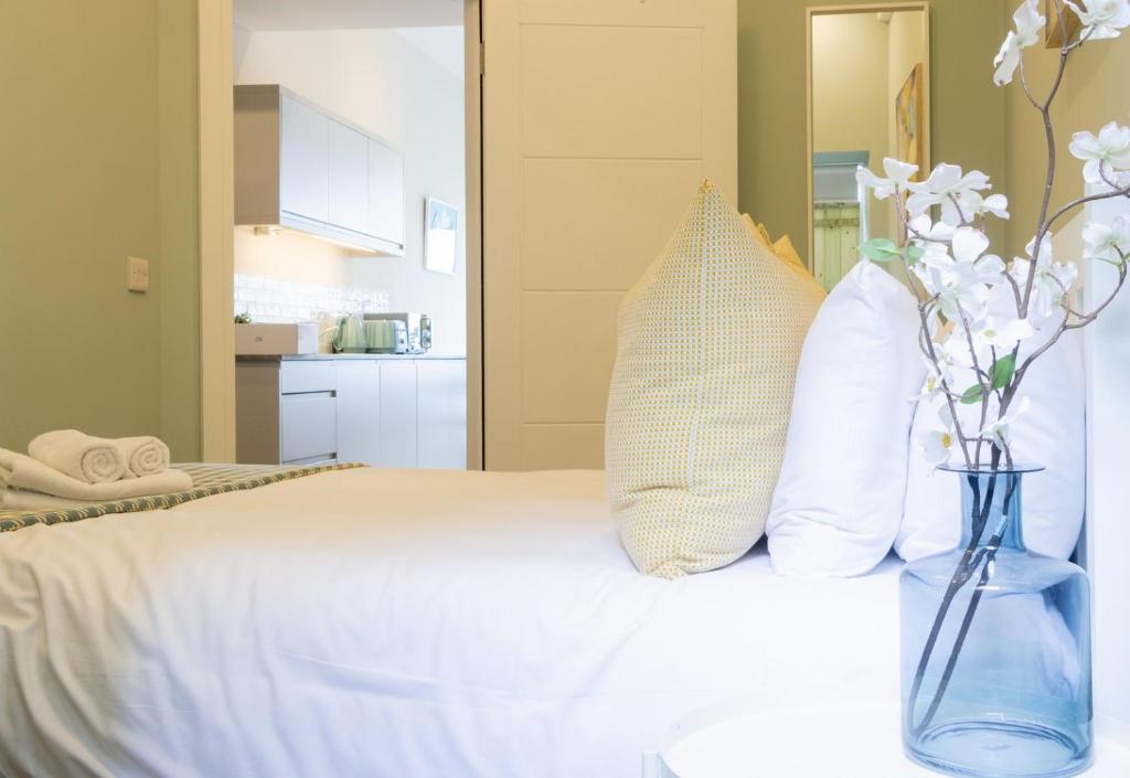 um quarto com uma cama com flores brancas num vaso em GuestReady - Dublin 8 Delight Retreat em Dublin