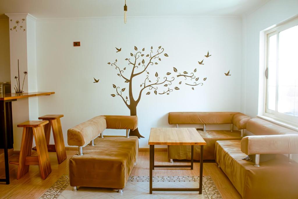 uma sala de estar com um sofá e uma árvore na parede em Hostel Albania em Tirana