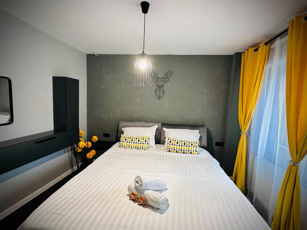 a bedroom with a bed with towels on it at Central Place to Stay in Reşiţa
