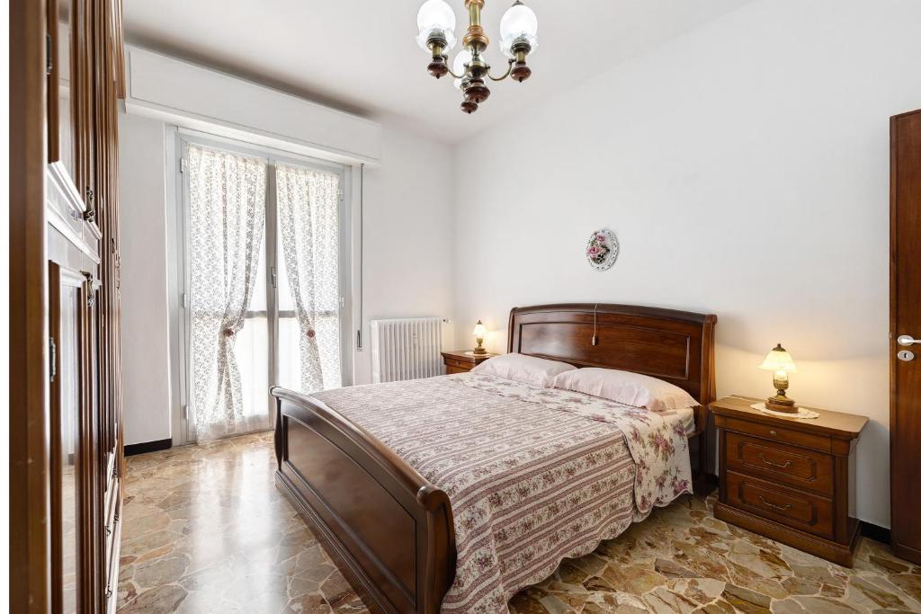 a bedroom with a bed and a chandelier at Casa Grace - Casa al Mare in Vado Ligure