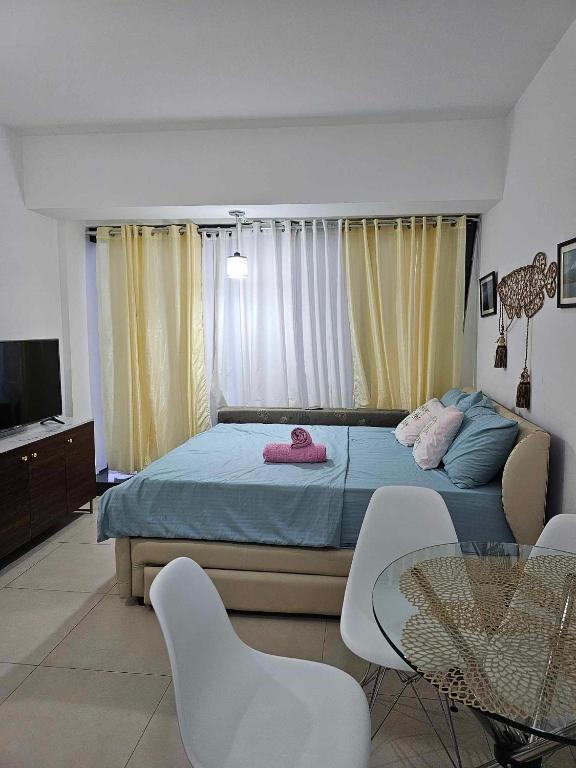 a bedroom with a bed and a table and chairs at Aeon Towers studio unit in Davao City