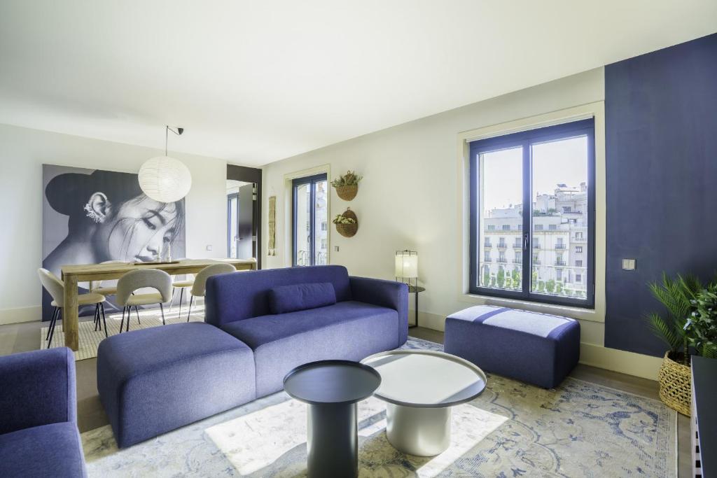 uma sala de estar com um sofá azul e uma mesa em Ola Living Paseo de Gracia em Barcelona