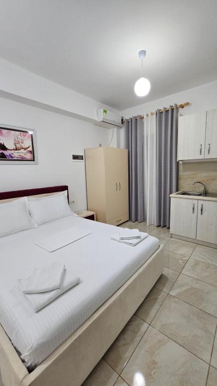 Vila Finnley في كساميل: غرفة نوم بها سرير أبيض كبير ومطبخ