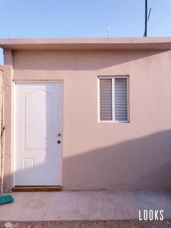 un edificio con una puerta blanca y una ventana en Departamento en ciudad Tipo Campirano, en Mexicali