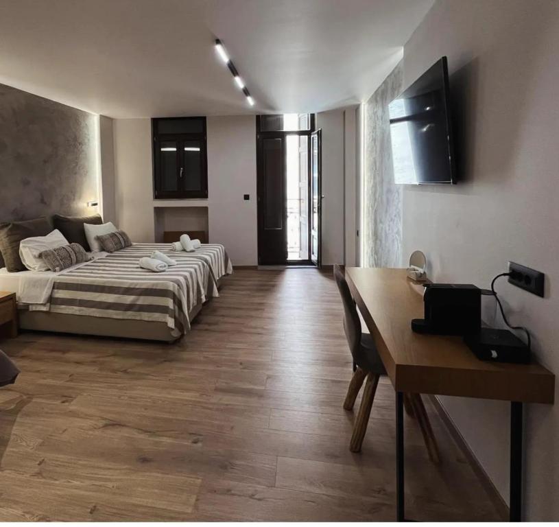1 dormitorio con cama, mesa y escritorio en Morfeas Hotel, en La Canea