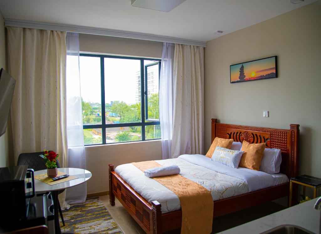 a bedroom with a bed and a large window at Oasis homes in Nairobi