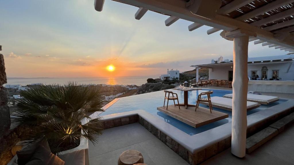 a villa with a view of the ocean at sunset at Nomia Sunset Suites Mykonos in Tagou