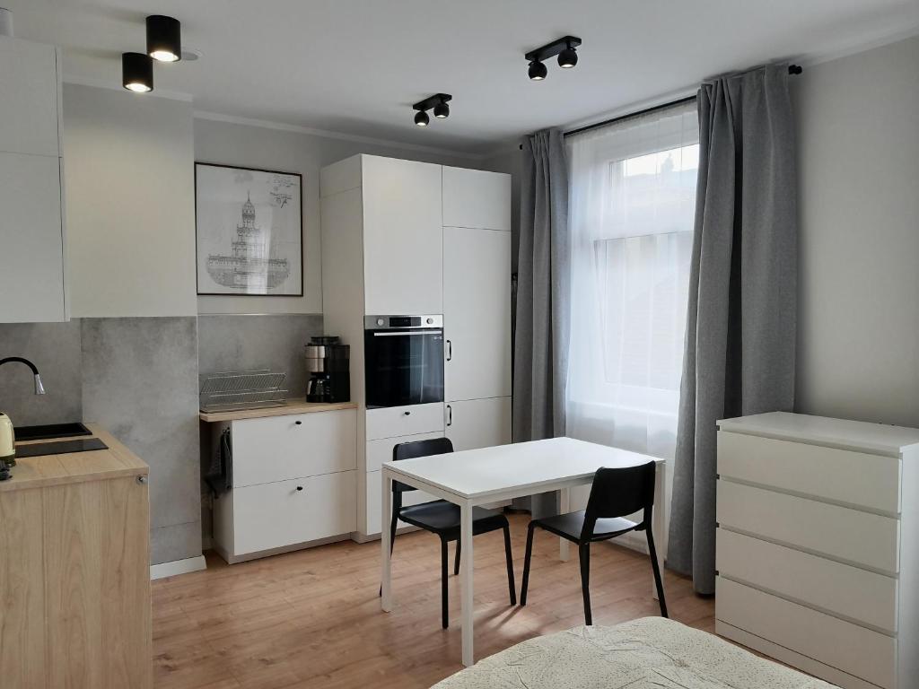 カトヴィツェにあるConcordia Apartmentのキッチン(白いテーブル、椅子付)