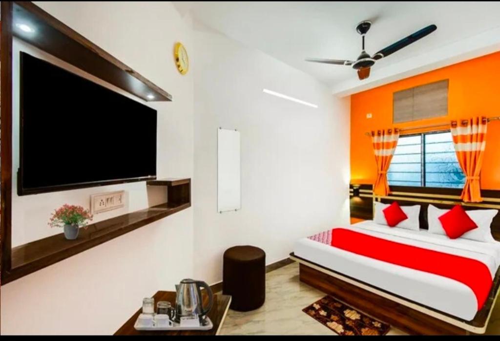 a bedroom with a large flat screen tv on the wall at Oyo chinar haven in Salua