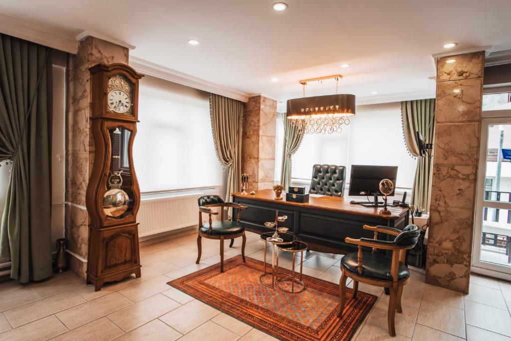 a home office with a desk and a grandfather clock at Samsun Charme Hotel in Samsun