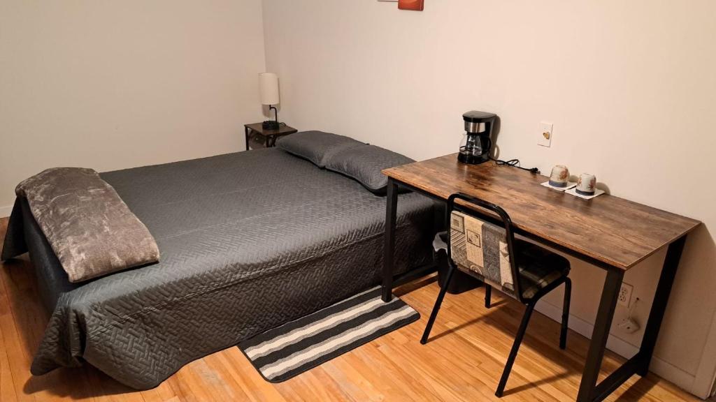 Schlafzimmer mit einem Bett und einem Holzschreibtisch in der Unterkunft Private Room 5 with Free WIFI and Parking in Edmundston