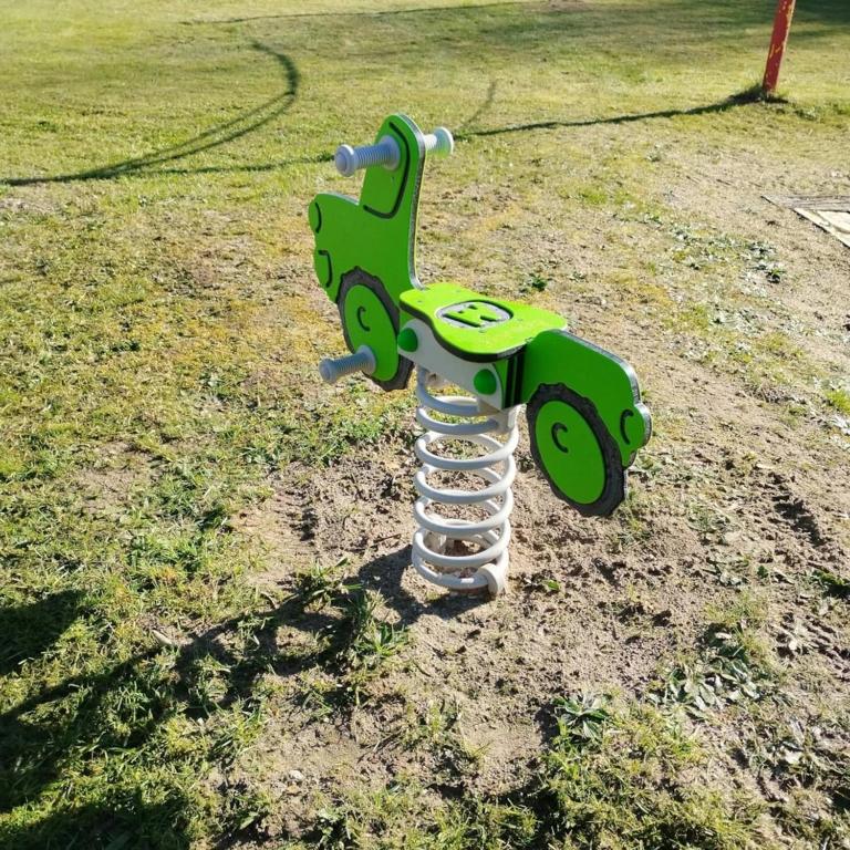 a statue of a green bike on the grass at Mobilhome 3 étoiles - efb0ib in Pendé