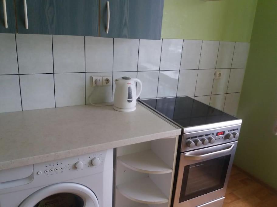 a kitchen with a counter with a dishwasher and a stove at Apartment in Pašilaičiai. Self check-in. Parking in Vilnius
