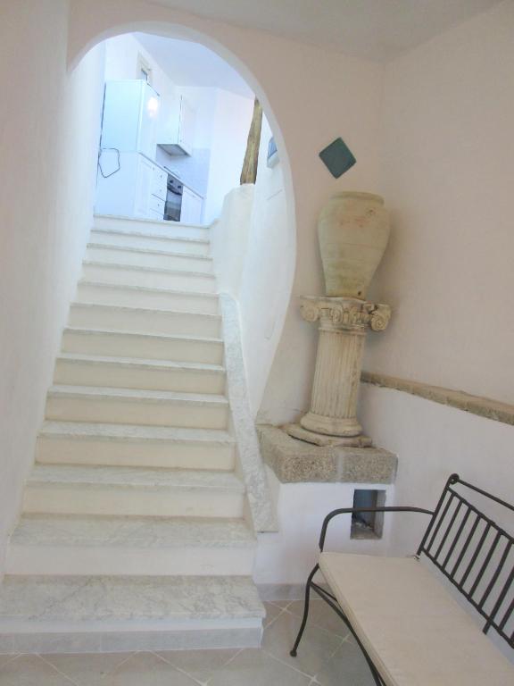 a staircase in a house with a chair and a vase at Sardinia Yellow House in Solanas