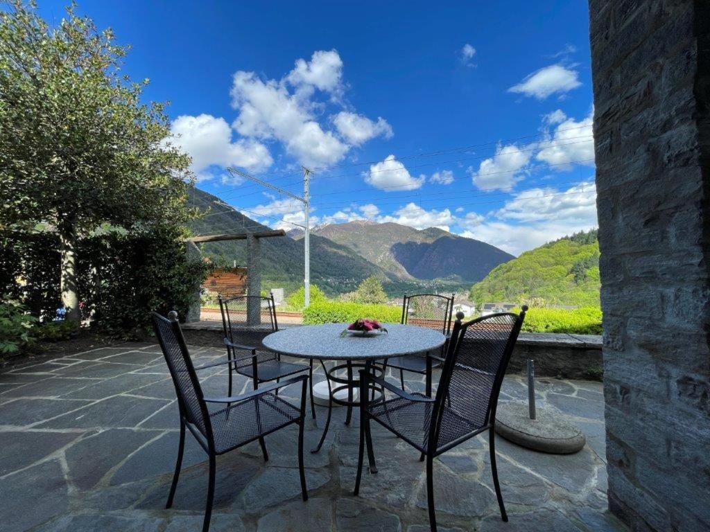 - une table et des chaises sur une terrasse avec vue sur les montagnes dans l'établissement Ristorante Stazione da Agnese & Adriana, à Intragna