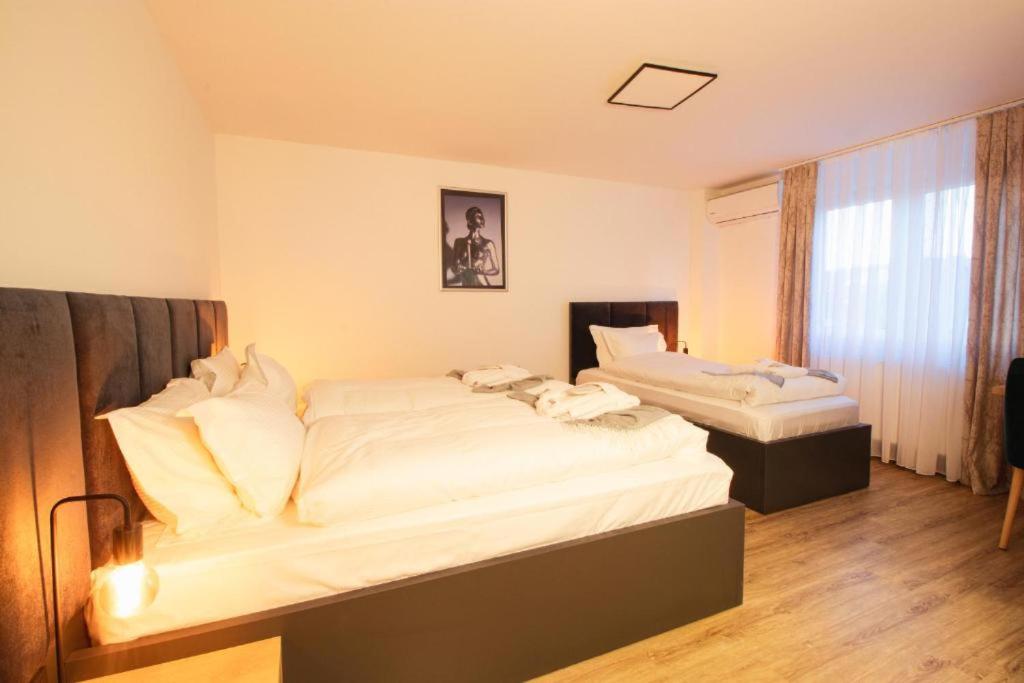 two beds in a room with white sheets at Hotel Dona in Bergisch Gladbach