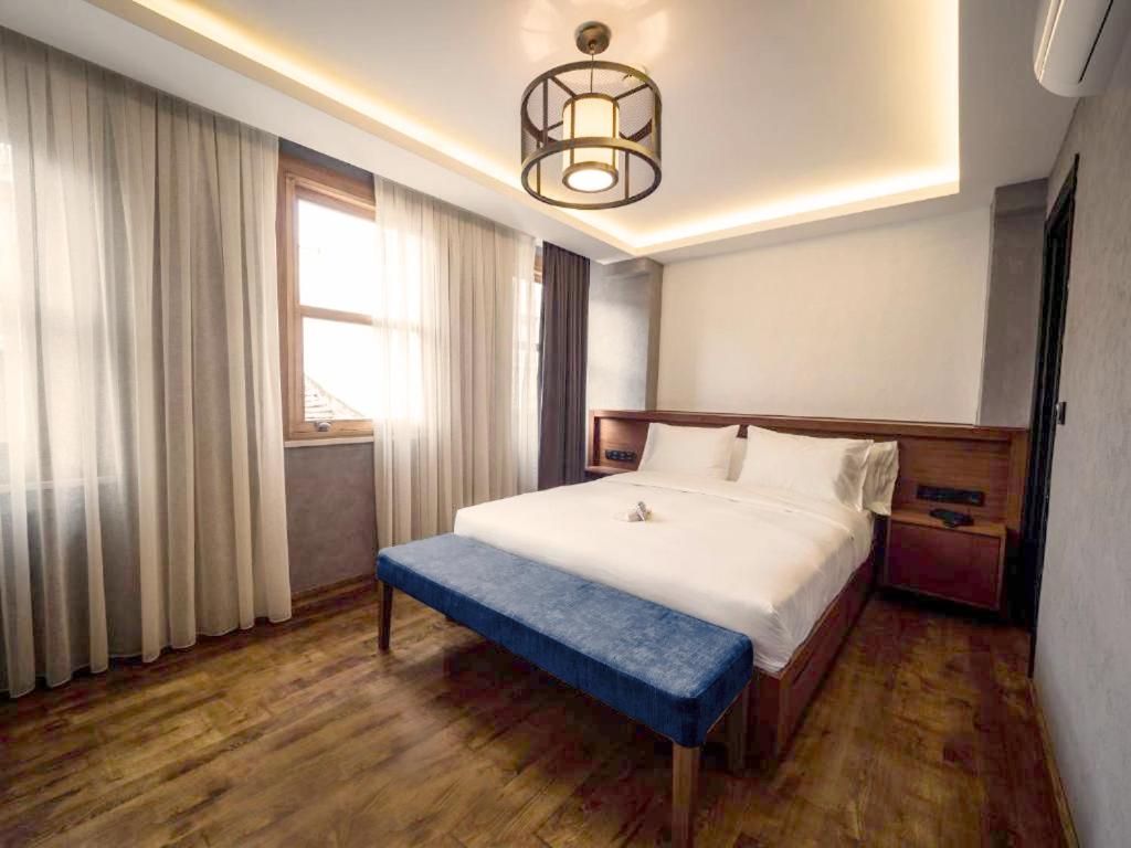 伊斯坦堡的住宿－GalataCo Hotel，一间卧室配有一张大床和蓝色长凳