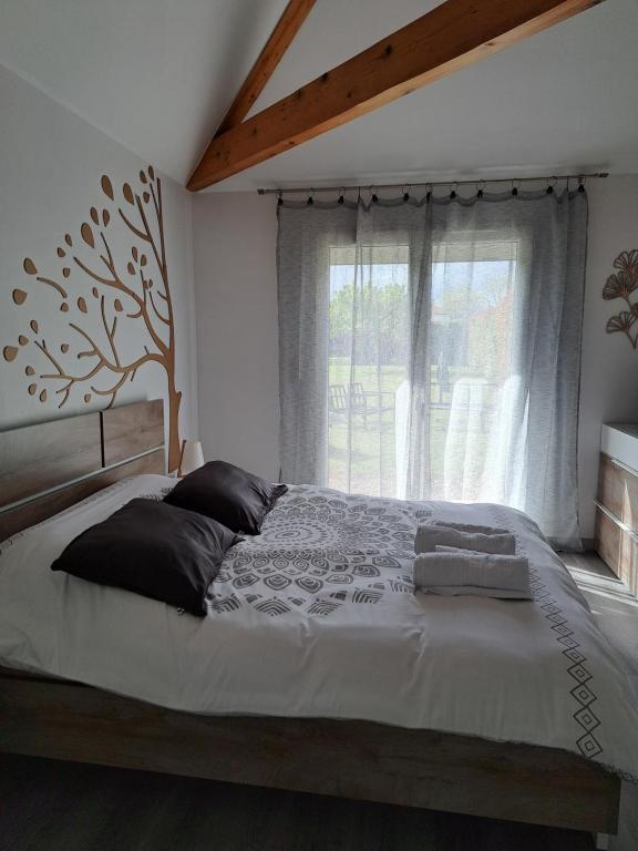 ein Schlafzimmer mit einem großen Bett und einem Fenster in der Unterkunft le chemin des Bérands chambres d'hôtes Renaison in Renaison