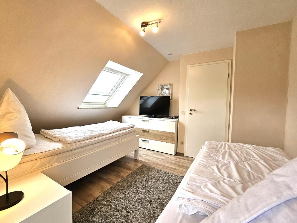 een slaapkamer met een bed, een tv en een raam bij Design Apartment Grünwald große Wohnung auf 2 Etagen in Hahnenklee-Bockswiese