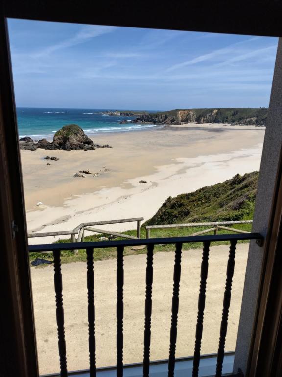 a view of a beach from a window at Hostal Restaurante Parajes in Castropol