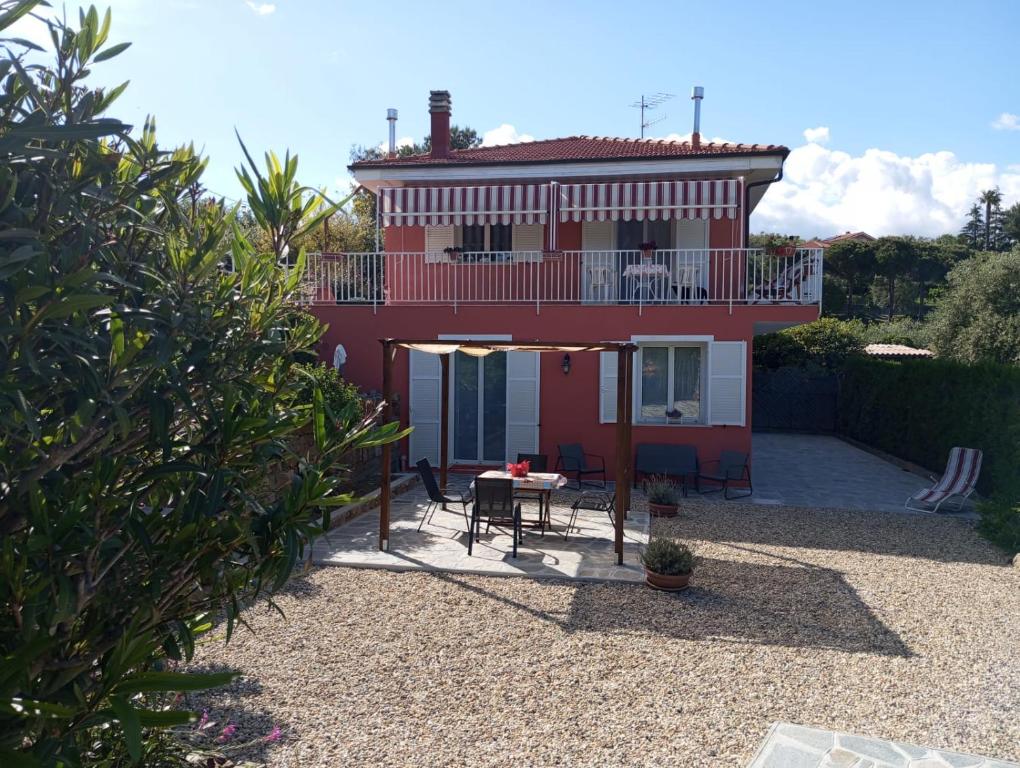 a red house with a table and a balcony at La casa di Giada, villetta indipendente con wi-fi e parcheggio gratuiti in Poggi