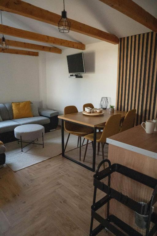 a living room with a table and a couch at Apartman River in Belišće