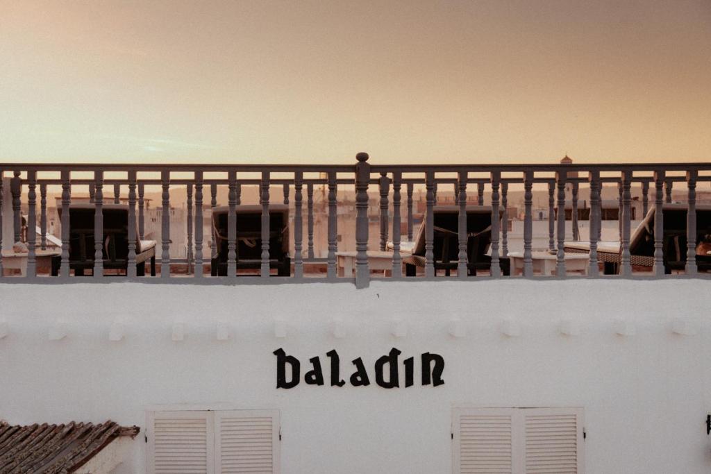 a balcony on top of a building with the word malcolm at Riad Baladin in Essaouira