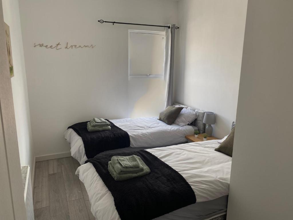 a bedroom with two beds with towels on them at Stylish Home - Close to City Centre, Anfield Stadium - Free Parking in Litherland