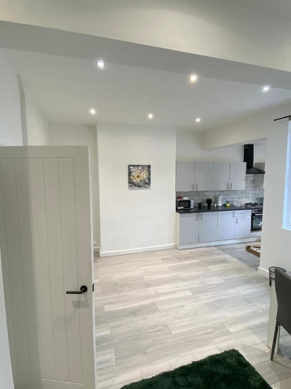 Hotel Stylish Home - Close to City Centre, Anfield Stadium - Free Parking, a living room with a door and a kitchen at Stylish Home - Close to City Centre, Anfield Stadium - Free Parking in Litherland