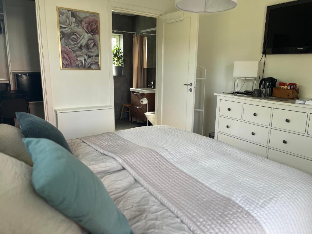 um quarto com uma cama grande e almofadas azuis em Boende med hotellkänsla i populära Skrea, Falkenberg em Falkenberg