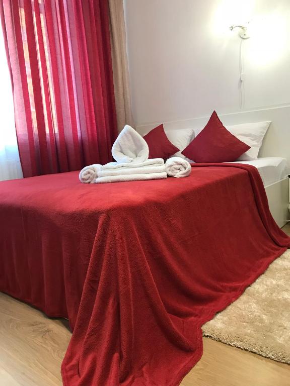 a bed with red sheets and towels on it at Light Apartments in Chernihiv